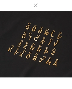 Detailed macro shot of gold-plated bamboo-textured 26 letter pendants for DIY jewelry