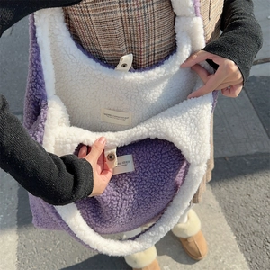 Detail of purple and white plush tote bag showing internal label and snap closure