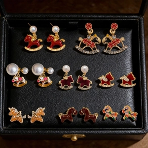 Macro view of a 7-pair luxury 18K gold plated horse stud earring set with enamel details