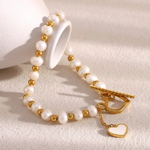 Detail of 18K gold-plated pearl bracelet with heart toggle clasp and white charm