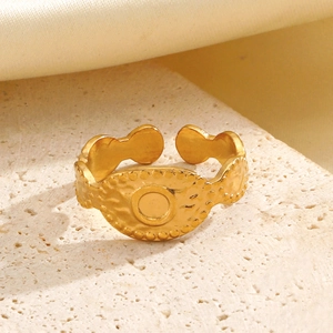 Vintage golden hammer-textured oval open ring with relief disc on a stone surface