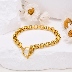 Elegant gold OT buckle pearl bracelet on white textured stone with white dried flowers