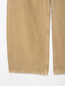 Detaillierte Nahaufnahme des khakifarbenen Twill-Baumwollstoffs und der Saumnaht dieser Jeans