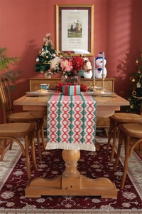 Detailed close-up of red and green woven diamond patterns and fringe on cotton table runner
