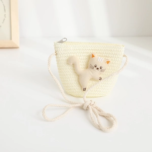 Detail of children's straw crossbody bag featuring a cute 3D plush cat and zipper closure