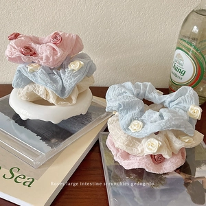 Floral fabric scrunchies with roses in pink, blue, and beige for elegant hairstyling