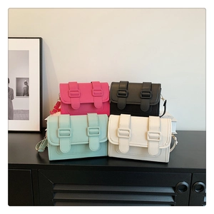 Detail view of retro small square crossbody bags in pink, black, green and white colors