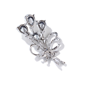Detailed back view of a silver flower brooch showing the secure pin clasp and zircon settings