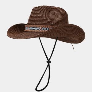 Detail of a brown woven straw cowboy hat with a colorful ethnic geometric embroidered band