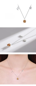Macro detail of S925 silver Pisces necklace with amber gemstone and zodiac charms