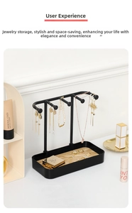 Detail of black metal jewelry organizer with wooden tray on a white vanity desk