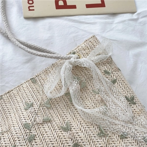 Straw tote bag with white lace bow and cotton rope strap for summer beach vacation