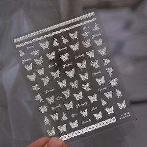 Detail of silver embossed butterfly and lace nail stickers with adhesive backing