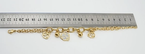 Detail of 22cm gold chain bracelet with hollow rose and rhinestone charms with ruler measurement