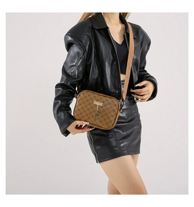 Brown monogram crossbody bag with gold hardware and deer charm worn by a model