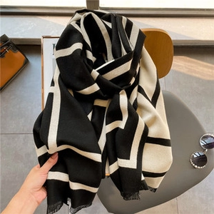 Detailed view of black and white geometric silk satin shawl draped over a vintage chair