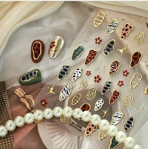 Detail of French animal print nail stickers with gold leopard and zebra patterns