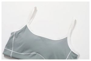 Detail of gray-blue sports bra with white flatlock stitching and contrast trim edges