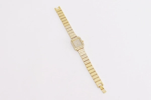 Macro shot of elegant gold-tone square watch encrusted with shimmering rhinestones