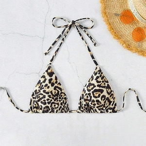 Flat lay of leopard print triangle bikini top with sunglasses and straw hat decor