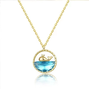 Elegant gold whale necklace with blue gemstone pendant and whale tail motif for women