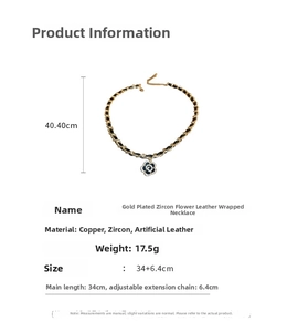 Close-up of camellia pendant with white zircons and leather-wrapped gold-plated chain