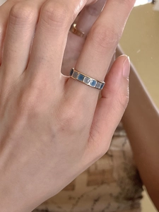 Detailed view of emerald green square enamel inlays on a golden minimalist ring