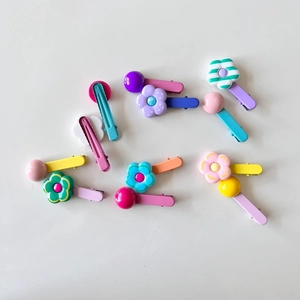 Detailed close-up of colorful flower and bead hair clips for girls on white background