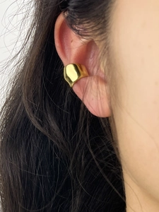 Detailed close-up of a glossy 18K gold-plated irregular horseshoe ear cuff on the ear