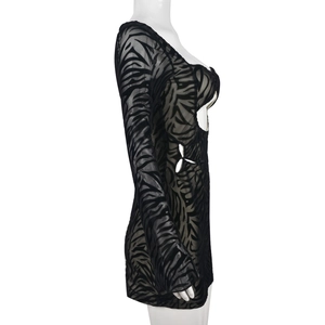 Détail du mesh à motif zébré et découpes sur une robe moulante noire à manches longues
