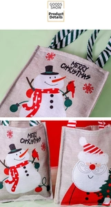Macro shot of faux burlap Christmas gift bags showing snowman and Santa print texture