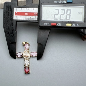 Detailed view of colorful zircon cross pendant showing 22.8mm width on a digital caliper