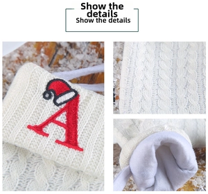 Detail of white knit Christmas stocking with red embroidered letter A and santa hat