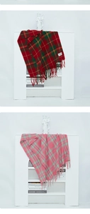 Detailed view of red and pink plaid scarves with soft fringe on a white mantelpiece