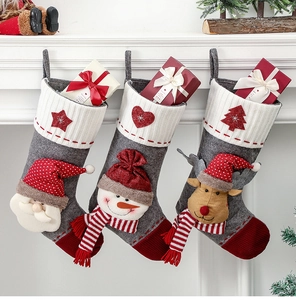 Détail de chaussettes de Noël en feutre gris avec personnages Père Noël, Bonhomme de neige