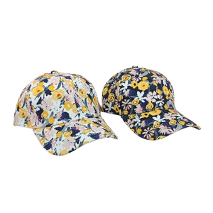 Detail of floral printed baseball caps featuring white and dark yellow flower patterns