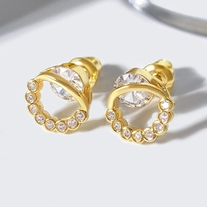 Retro round hollow earrings with gold plating and cubic zirconia in a macro view