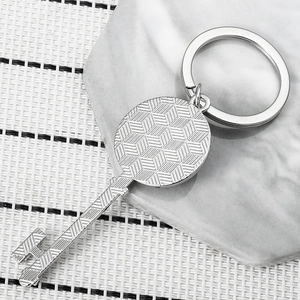 Detailed view of silver key keychain with geometric 3D cube texture and industrial metal ring