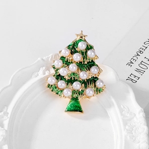 Macro detail of Christmas tree brooch with emerald enamel, pearls and gold star