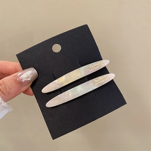 Detail of iridescent white acetate hair clips with gold Barrette La France lettering