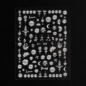 Detail view of 5D embossed nail art stickers with white daisy floral and letter designs