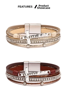 Detail of layered leather bracelets with BLESSED cross charm and magnetic metal clasp