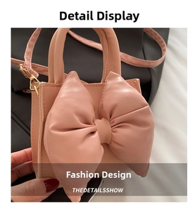 Close-up of pink mini handbag featuring a large decorative bow and detachable shoulder strap