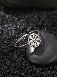 Glow-in-the-dark stainless steel ring with Nordic symbol on professional stone display