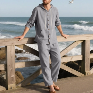 Detail of grey men's linen hooded shirt and pants set on a sunny beach boardwalk