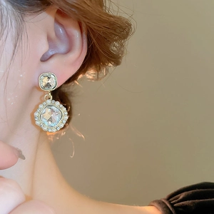 Detailed close-up of vintage French earrings with pearls and crystal inlays on a model