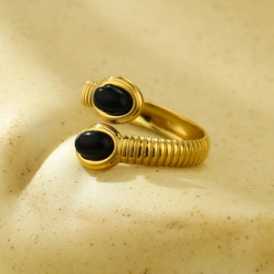 Close-up of gold stainless steel ring featuring textured band and black oval gemstones