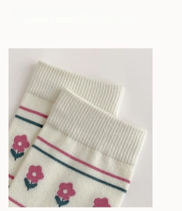Gros plan de chaussettes en coton avec motifs floraux, rayures et bords-côtes