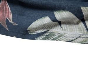 Macro shot of navy blue polo shirt with tropical leaf print and precise hem stitching