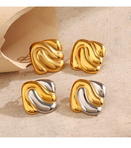 Detail of geometric wave-shaped earrings in gold and silver finish on textured background